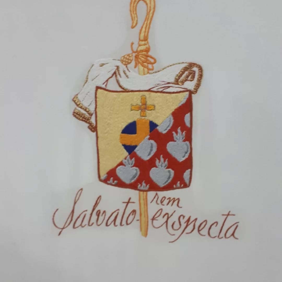 Brasão abacial bordado à mão: o escudo com a cruz, os corações e o báculo, sob a divisa Salvatorem exspecta.