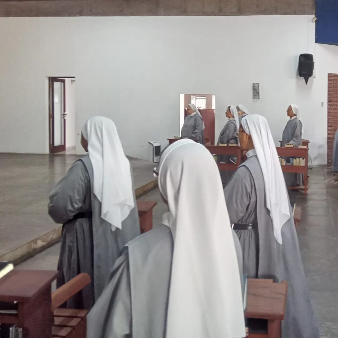 Monjas de véu branco no coro, durante a liturgia das horas.