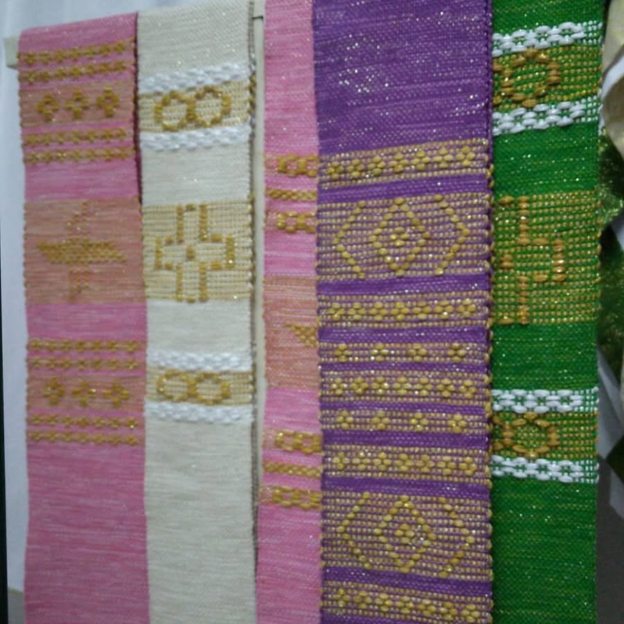 Galões tecidos em tear manual nas cores litúrgicas — rosa, branco, roxo e verde — com desenhos em fio dourado.